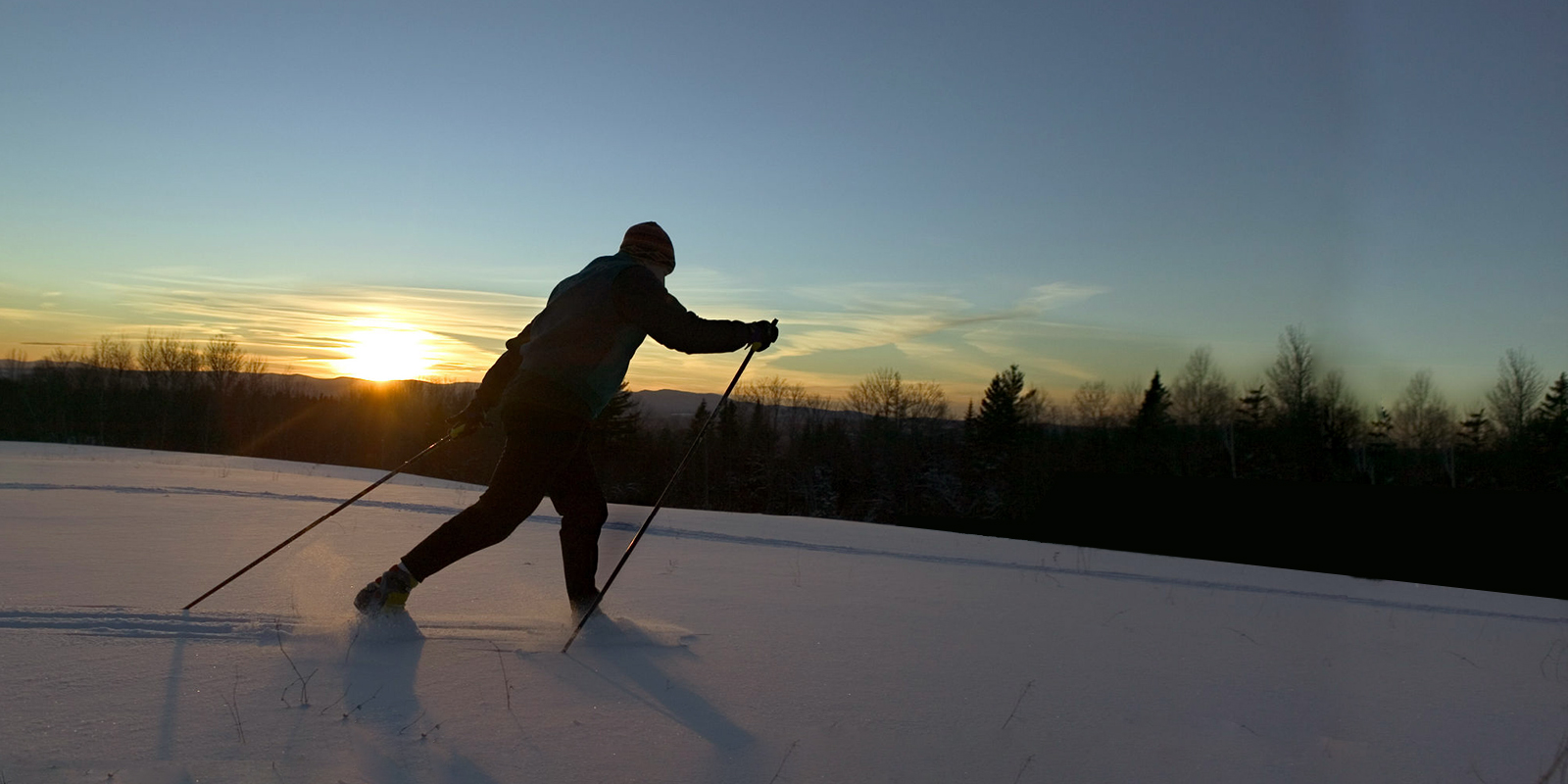 A cross country skier glides across the landscape leanto
