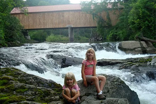 Playing in the river by the covered bridge