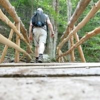 A hiker crosses a mountain stream using one of the newly built bridges on the Norcross Trail. Photos provided by ATA.