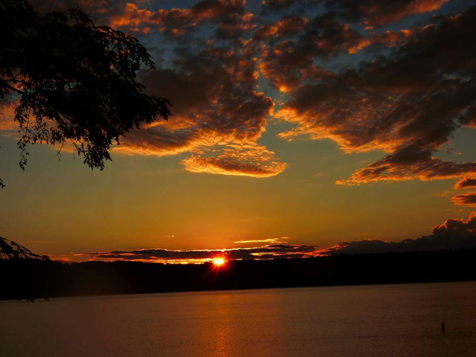 A sunset lights up the sky at Lake Carmi State Park, by Marlene Handler.