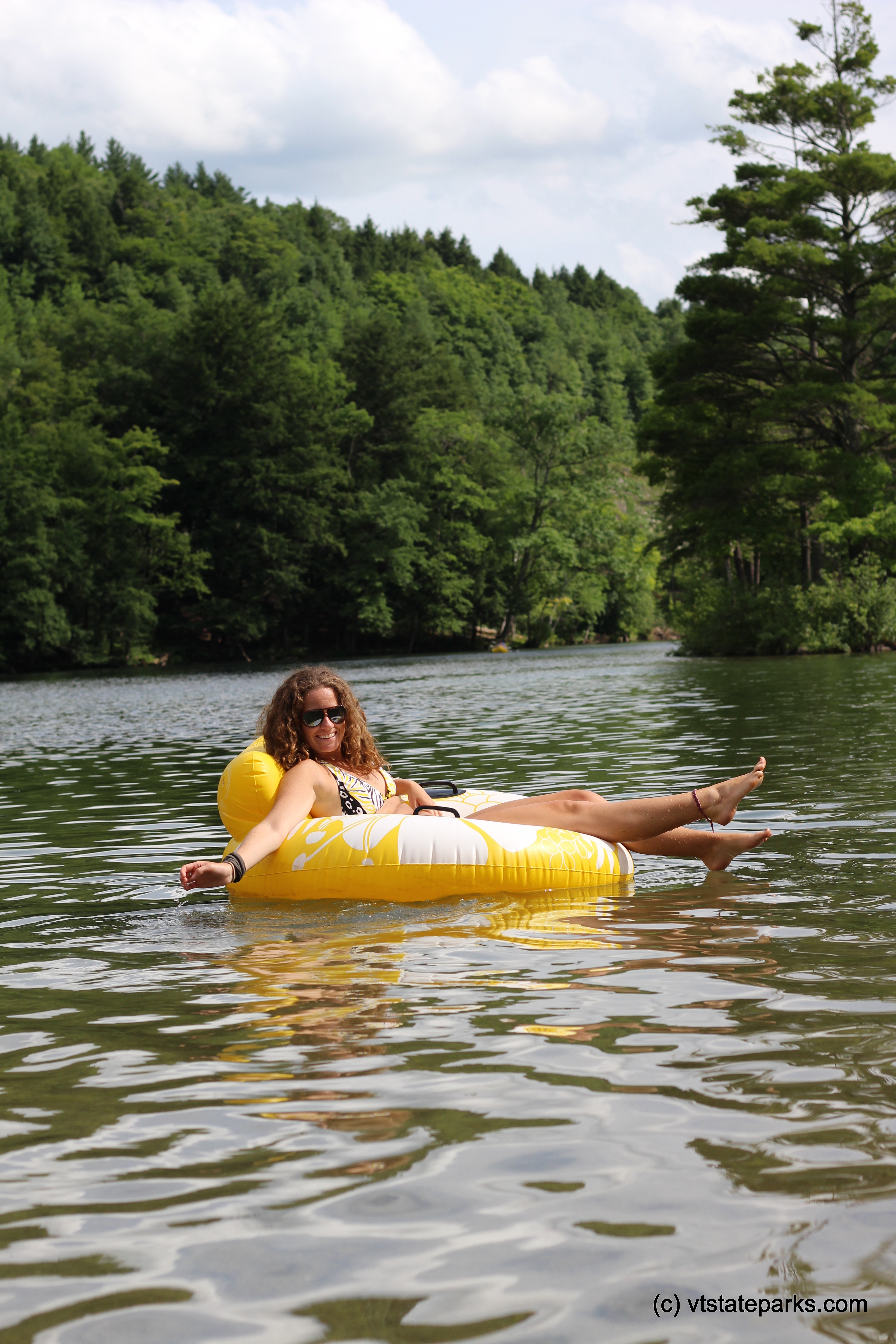 A girl relaxing on a tube in the water at Emerald Lake State Park by Cara Goodenough