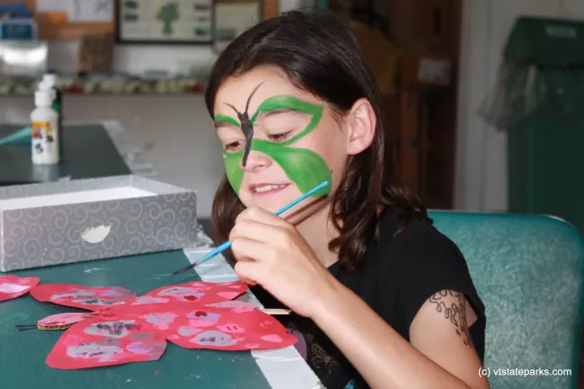 Painting a butterfly to match her face at Grand Isle State Park by Julie Lyman