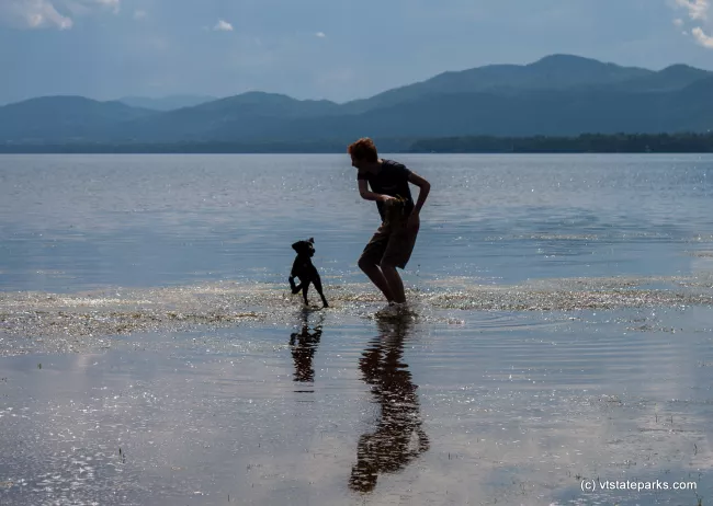 A man and his playful friend in Lake Champlain from Button Bay State Park by Tara Schatz
