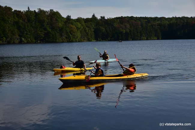 A group of kayakers glide over the water at Woodford State Park by Bill Steele