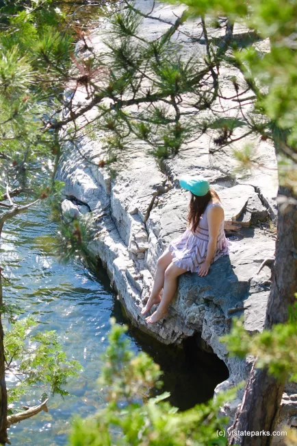 Girl sits by water at Niquette Bay State Park by Bryce Metzger