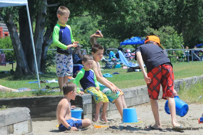 Group of cool guys playing in the sand at Elmore State Park by Joanne Pereira