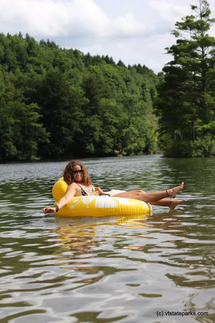 A girl relaxing on a tube in the water at Emerald Lake State Park by Cara Goodenough