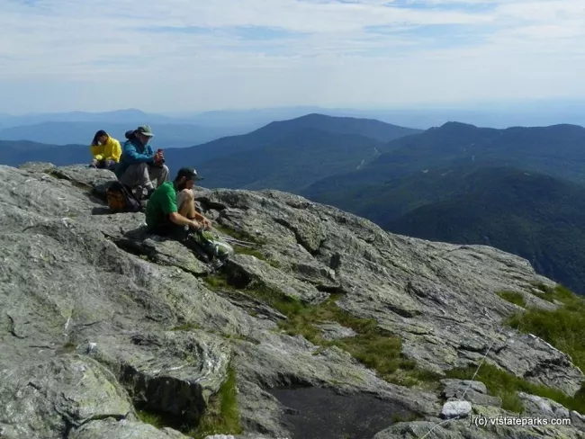 Caregiver sitting on summit from trail at Underhill State Park by John Predom