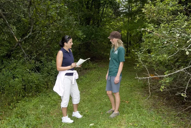 Bomoseen State Park employee Keely Flynn leads Gillian Pieper of Hinesburg, VT along the Slate History trail. The 3/4 mile trail leads explorers through the remains of the West Castleton Railroad and Slate Company. (Photo by Karen Pike)