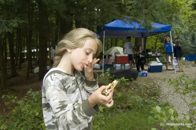 Jacklyn Carrara enjoys a smore while camping with her family at Half Moon Pond State Park. Photo by Karen Pike