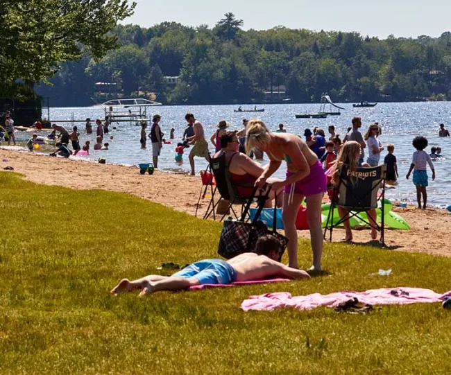 People relaxing at a beach at a Vermont State Park