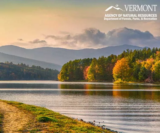 A landscape photo taken in the evening of a lake in Vermont in early fall.